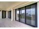 Spacious tiled balcony featuring sliding glass doors, neutral colors, and views of the tranquil waterfront at 50 Coe Rd # 223, Belleair, FL 33756