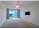 Bright bedroom with a ceiling fan, waterfront views and a balcony with sliding glass doors at 50 Coe Rd # 223, Belleair, FL 33756