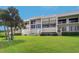 Modern condo building with an inviting balcony, and lush green lawn at 50 Coe Rd # 223, Belleair, FL 33756