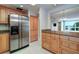 Kitchen features stainless steel refrigerator, granite countertops, and wood cabinets at 50 Coe Rd # 223, Belleair, FL 33756
