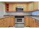 Updated kitchen featuring stainless steel appliances, granite countertops, and wood cabinets at 50 Coe Rd # 223, Belleair, FL 33756