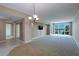 Spacious living room featuring carpeted floors, a modern light fixture, and sliding glass doors with stunning water views at 50 Coe Rd # 223, Belleair, FL 33756