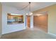 Open living space with tan carpet and kitchen view featuring granite countertops and wood cabinetry at 50 Coe Rd # 223, Belleair, FL 33756