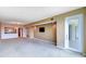 Spacious living room featuring neutral carpet, wall-mounted TV, and access to the outdoors at 50 Coe Rd # 223, Belleair, FL 33756