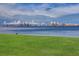 Scenic waterfront view featuring lush green space and a distant cityscape under a bright, cloudy sky at 50 Coe Rd # 223, Belleair, FL 33756