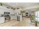 Open-concept kitchen features stainless steel appliances, white cabinets, and eat-in dining area with a fireplace at 503 Old Grove Dr, Lutz, FL 33548