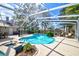 Stunning screened-in pool and spa area with ample patio space, lush landscaping, and inviting lounge chairs at 503 Old Grove Dr, Lutz, FL 33548