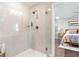 Modern bathroom with glass shower, tiled walls, and view to the primary bedroom at 5351 Bridge St # 41, Tampa, FL 33611