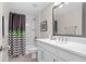 Well-lit bathroom featuring a modern vanity, framed mirror, and a shower with stylish chevron curtain at 5351 Bridge St # 41, Tampa, FL 33611