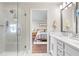Bright bathroom with double vanity, glass shower, and view into bedroom at 5351 Bridge St # 41, Tampa, FL 33611