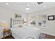 Neutral bedroom with two windows, ceiling fan, hardwood floors, and a full-size metal bed frame at 5351 Bridge St # 41, Tampa, FL 33611