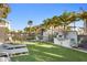 Outdoor community space with lush green lawn, lounge chairs, and a built-in grilling area under palm trees at 5351 Bridge St # 41, Tampa, FL 33611
