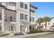 Elegant white townhouse featuring a private balcony, charming front entrance, and lush landscaping at 5351 Bridge St # 41, Tampa, FL 33611