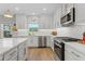 Bright kitchen with white cabinets, stainless steel appliances, and wood-look flooring at 5351 Bridge St # 41, Tampa, FL 33611