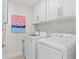 Functional laundry room with modern washer and dryer, plus upper cabinets for organized storage at 5351 Bridge St # 41, Tampa, FL 33611