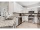 Modern kitchen with stainless steel appliances, granite countertops, and white cabinetry at 5514 Tidal Breeze Cv, Bradenton, FL 34211