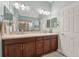 Bathroom featuring dual sinks, wood cabinets, and large mirror at 6152 Cliff House Ln, Riverview, FL 33578