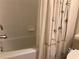 Clean, well-maintained bathroom with a classic bathtub and shower combination with a bamboo curtain for privacy at 6815 Dali Ave # F101, Land O Lakes, FL 34637