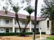 Low-rise condo complex shows off a tile roof, exterior balconies, and mature palm trees at 6815 Dali Ave # F101, Land O Lakes, FL 34637