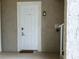 White front door with secure entry and welcome mat leading into condo unit at 6815 Dali Ave # F101, Land O Lakes, FL 34637