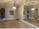 Open living area with tile floors, a large mirror, stylish lighting, and partial kitchen view at 6815 Dali Ave # F101, Land O Lakes, FL 34637