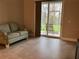 Cozy living room with tile floors, a comfortable sofa, and sliding glass doors leading to an enclosed patio area at 6815 Dali Ave # F101, Land O Lakes, FL 34637