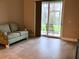 Condo living space featuring a green sofa and sliding glass doors leading to patio at 6815 Dali Ave # F101, Land O Lakes, FL 34637