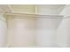Simple, white walk-in closet features shelving and clothing racks for ample storage at 7200 Ulmerton Rd # B4, Largo, FL 33771