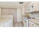 Kitchen with white appliances, countertop seating, and clean, bright finishes at 7200 Ulmerton Rd # B4, Largo, FL 33771