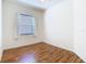 A bright bedroom with wood-look flooring, a window and white walls, offering a simple space at 7743 Bingham Ct, Tampa, FL 33625