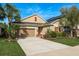 Inviting single-Gathering home with lush landscaping, a two-car garage, and red shutters under a vibrant blue sky at 9818 Stillchase St, Tampa, FL 33625