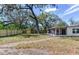Spacious backyard featuring a privacy fence, mature trees, and screened in patio at 303 Suzette Dr, Brandon, FL 33511