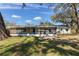 A full back view of the home including a large screened in patio and a large grassy area at 303 Suzette Dr, Brandon, FL 33511