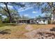 Back of house featuring a screened in patio and a large grassy area with a privacy fence at 303 Suzette Dr, Brandon, FL 33511