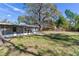Large backyard area with mature trees and screened in patio, great for outdoor living at 303 Suzette Dr, Brandon, FL 33511
