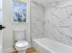 Bathroom with white marble-patterned tile surround on the walls, and a bright window for natural light at 303 Suzette Dr, Brandon, FL 33511