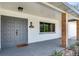 A view of the front porch featuring gray double doors and natural wood pillars at 303 Suzette Dr, Brandon, FL 33511