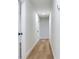 Hallway with light wood flooring and white walls leading to a bathroom and several bedrooms at 303 Suzette Dr, Brandon, FL 33511