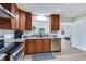 Well-lit kitchen featuring stainless steel appliances, granite countertops, and wooden cabinetry at 303 Suzette Dr, Brandon, FL 33511