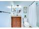 A clean bathroom featuring a wooden vanity and a framed 'give thanks' sign to the right of the toilet at 114 Laurel Tree Way, Brandon, FL 33511