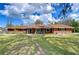 Charming brick home featuring a large front yard, cozy porch, and inviting curb appeal at 114 Laurel Tree Way, Brandon, FL 33511