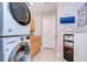 Spacious laundry room featuring a stacked washer/dryer set and decorative storage shelves at 114 Laurel Tree Way, Brandon, FL 33511