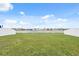 Scenic backyard featuring green grass with a view of a tranquil lake and white fencing at 11544 Brighton Knoll Loop, Riverview, FL 33579