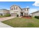 Inviting two-story home featuring a two-car garage, brick driveway, and well-maintained landscaping at 11544 Brighton Knoll Loop, Riverview, FL 33579
