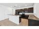 Modern kitchen with dark cabinets, granite countertops, tile flooring, and a functional breakfast bar at 11544 Brighton Knoll Loop, Riverview, FL 33579
