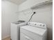 Well-lit laundry room featuring a washer, dryer and wire shelving at 11544 Brighton Knoll Loop, Riverview, FL 33579