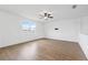 Bright, airy living room with wood floors, large window, and minimalist decor at 11544 Brighton Knoll Loop, Riverview, FL 33579