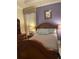 Cozy bedroom with a wooden bed frame, dresser, ample lighting, and neutral-toned walls at 11648 Palmetto Pine St, Riverview, FL 33569