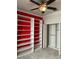Well-organized closet with shelving, hanging rods, and ample storage space, with a red accent wall at 11648 Palmetto Pine St, Riverview, FL 33569