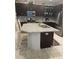 Bright kitchen showcasing stainless steel appliances, dark cabinets, a center island with seating, and stylish backsplash at 11648 Palmetto Pine St, Riverview, FL 33569